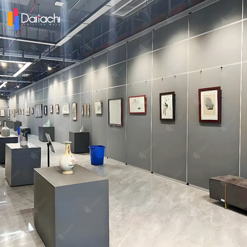 The exhibition hall features simple, gray, manually operated movable partition walls.